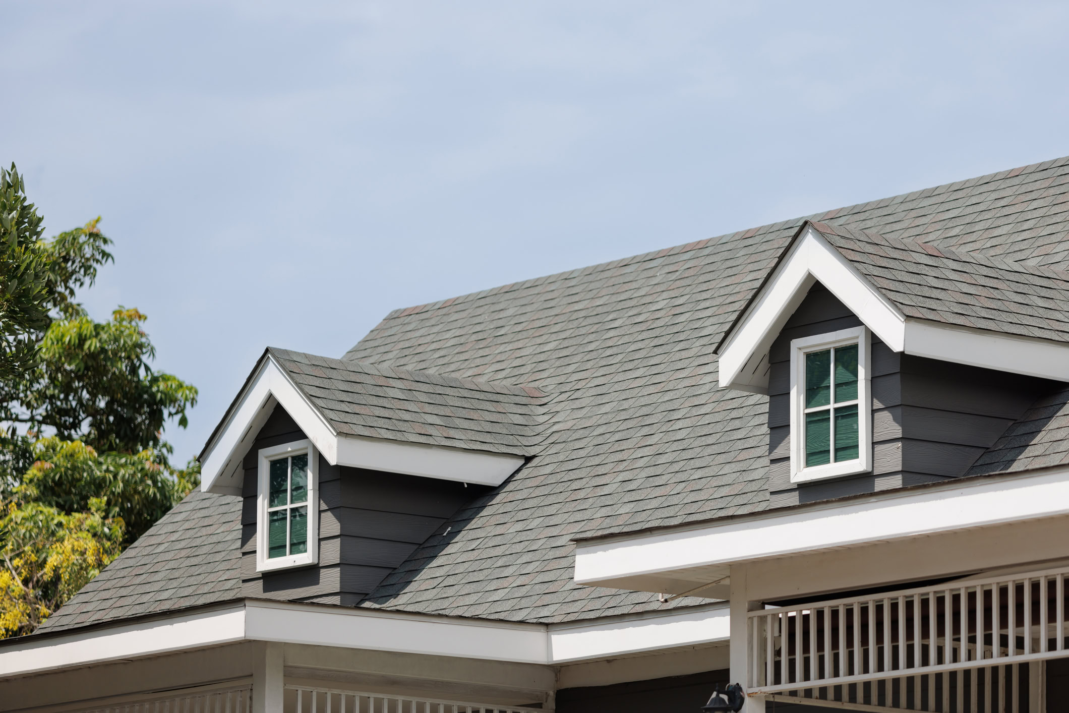 Angled view of shingled roof with second-story windows